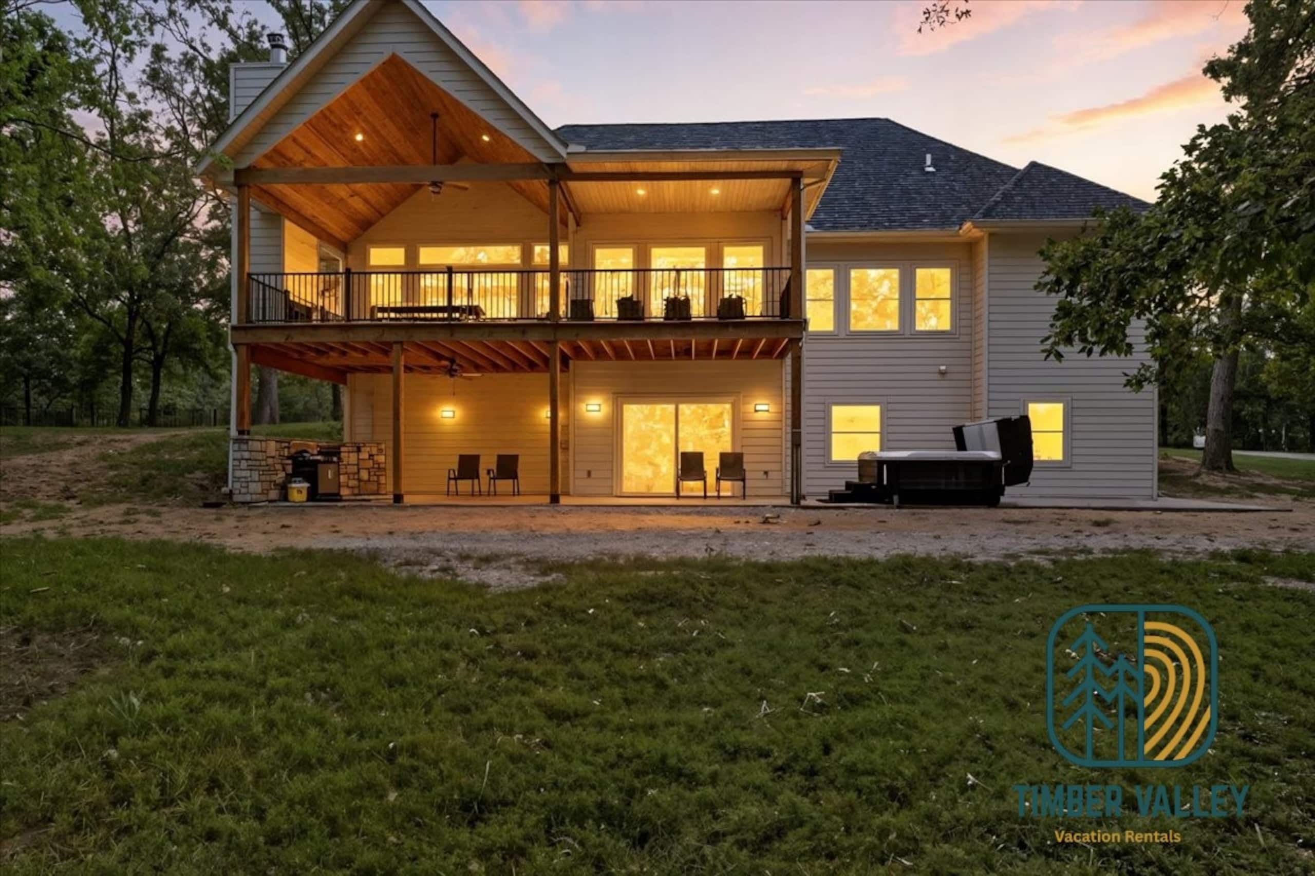 Russell Township house at dusk, deck lights on